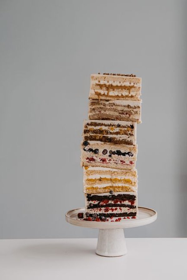 A tall stacked layer cake on a cake stand.