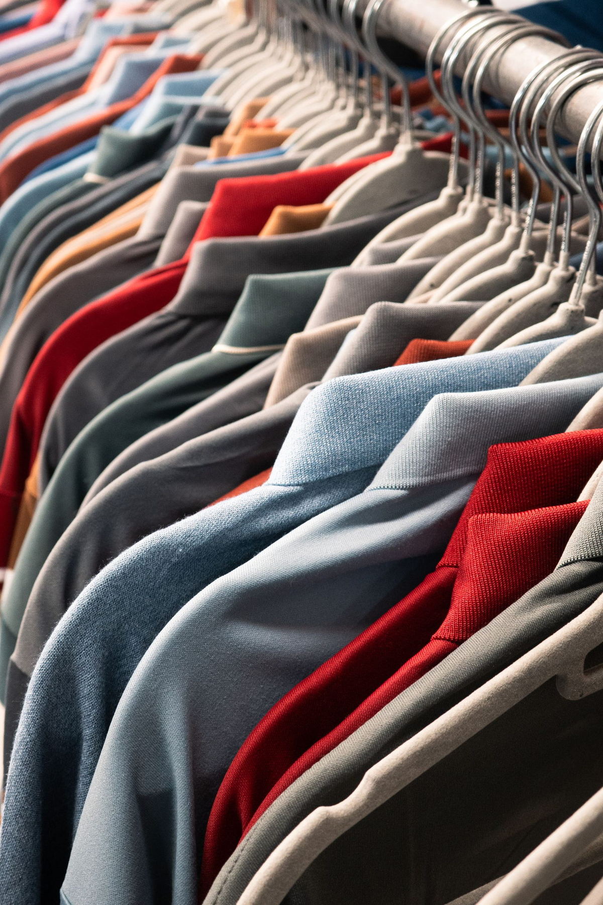 A packed rail of pressed shirts on matching hangers, seen along the rod